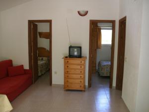 sala de estar con sofá rojo y tocador con TV en Holiday home Vakantiepark Isábena 6, en La Puebla de Roda