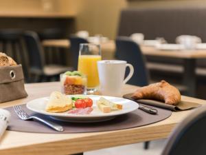 un plato de comida en una mesa con un vaso de zumo de naranja en Hotel Savoy, en Berna