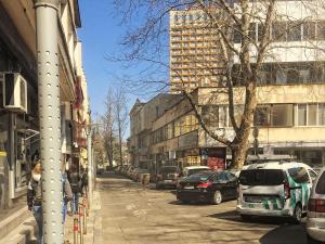 Una calle de la ciudad con coches aparcados en la calle. en Central studio 1, en Burgas