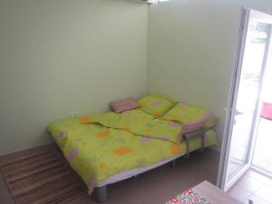 Dormitorio pequeño con cama con edredón verde en Apartment Camp Ajdovščina, en Ajdovščina