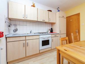 a kitchen with white cabinets and a wooden table at Dog friendly holiday home in Hesse with garden in Bad Zwesten