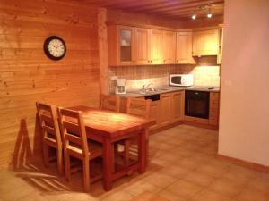 a kitchen with a wooden table and a clock on the wall at Chalet des Cascades in Sixt