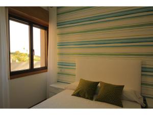 モンタルボにあるBelvilla by OYO Playa Montalvo Bajo 4のベッドルーム1室(ストライプの壁のベッド1台付)