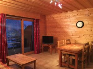 a dining room with a table and a clock on the wall at Chalet des Cascades in Sixt