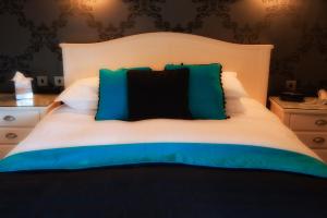a bedroom with a bed with blue and green pillows at The Grafton in Harrogate