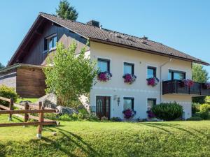 a white house with flowers on the windows at Apartment in Bernau Black Forest with valley view in Bernau im Schwarzwald
