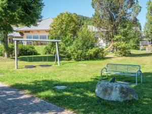 a park with a bench and a rock in the grass at Apartment in Bernau Black Forest with valley view in Bernau im Schwarzwald