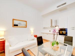 ein Wohnzimmer mit einem Glastisch und einer weißen Couch in der Unterkunft Queen Palace Suites in Rom