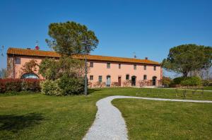 a path leading to a large building in a field at La Magnifica B&B in Fauglia