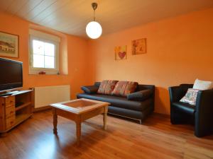 a living room with a couch and a tv at Spacious Apartment in Meisburg with Terrace in Meisburg