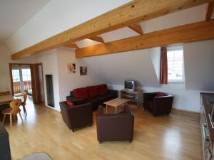 ein Wohnzimmer mit einem Sofa und Stühlen in der Unterkunft Apartment in Sankt Margarethen near Ski Area in Sankt Margarethen im Lungau