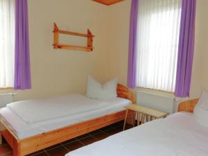 two beds in a room with purple curtains at Pleasant Holiday Home With Terrace in Schirgiswalde Germany in Schirgiswalde