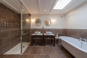 a bathroom with two sinks and a bath tub at Hubbard's Luxury Bed and Breakfast in South Creake