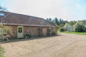 a brick house with a white door and a dirt road at Hubbard's Luxury Bed and Breakfast in South Creake