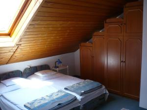 a bedroom with a bed and a wooden ceiling at Jankó Apartmanház in Zalakaros