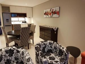 sala de estar con mesa y sillas y cocina en Zimbali Suites 106 en Ballito