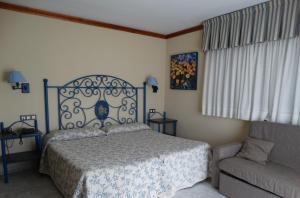 1 dormitorio con 1 cama y 1 sofá en Hotel Los Juncos, en Noja