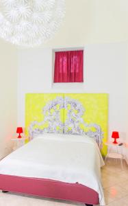 メルフィにあるLe Stanze Dell'Imperatore B&Bのベッドルーム1室(白いベッド1台、赤と黄色の絵画付)