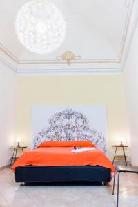 1 dormitorio con 1 cama grande con manta naranja en Le Stanze Dell'Imperatore B&B, en Melfi