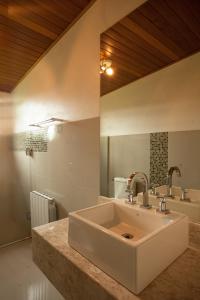 a bathroom with a white sink and a mirror at Casa Blauth in Farroupilha