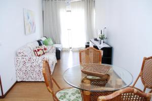 uma sala de estar com uma mesa e cadeiras de vidro em Apartamento Varandas Barra Flat no Rio de Janeiro