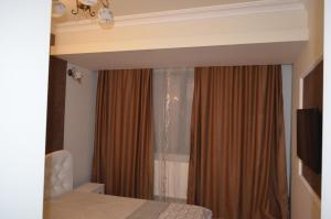 ママイア・ノルドにあるApartament Casyana - Mamaia Nordのベッドルーム1室(ベッド1台付)、窓(カーテン付)
