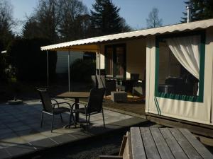 een huis met een tafel en stoelen op een patio bij Chalet Wester Park Lierderholt in Beekbergen