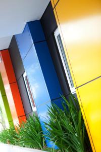 a colorful facade of a building with a plant at Amaris Hotel Cimanuk Bandung in Bandung