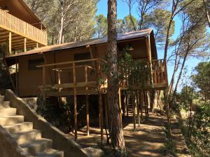 a house in the woods with stairs leading up to it at Glamping Lodge Estartit in L'Estartit