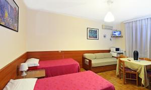 a hospital room with two beds and a table at Hotel Residence Sogno in Novara