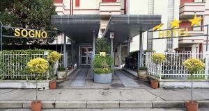 un negozio di fronte a un hotel con piante in vaso di Hotel Residence Sogno a Novara