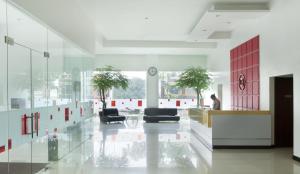 a lobby with chairs and a clock in a building at Amaris Hotel Cihampelas in Bandung