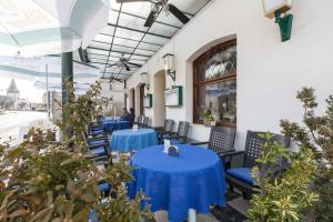 un restaurante con mesas azules, sillas y plantas en Hotel DeFive en Berdorf