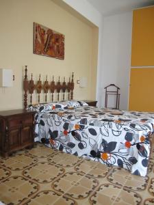 a bedroom with a bed with a colorful comforter at La Casa di Rosa in Ioppolo