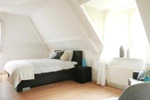 a bedroom with a bed in a attic at PicaBella - B&B en atelier in Laren