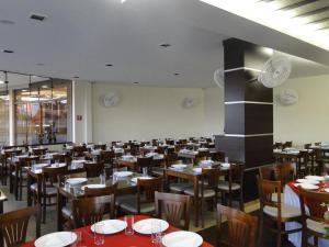 un comedor con mesas y sillas en un restaurante en Hotel Portal en Carlópolis