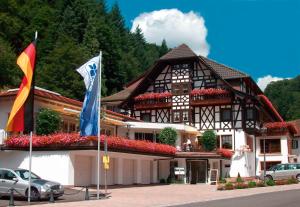 un bâtiment avec deux drapeaux devant lui dans l'établissement Flair Hotel Adlerbad, à Bad Peterstal-Griesbach