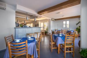 a dining room with blue tables and chairs at Pelagia Aphrodite Hotel in Agia Pelagia