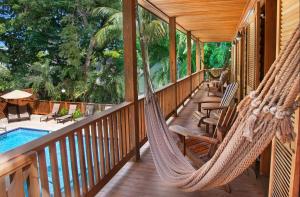 a porch with hammocks and a pool on a house at Island City House in Key West