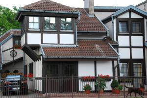 a white and black house with a dog in front of it at Maryla in Kołobrzeg