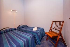 カステッランマーレ・デル・ゴルフォにあるAppartamento Mediterraneoのベッドルーム1室(ベッド2台、木製椅子付)