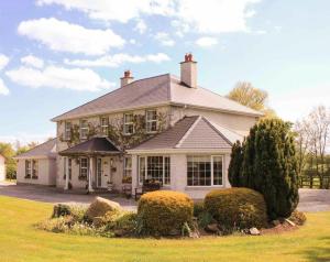 a large white house with a roof at Orchard Grove bed & breakfast R21RC58 in Bagenalstown