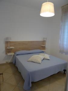 マリーナ・ディ・モーディカにあるMarina di Modica Suiteのベッドルーム(青いベッド、ライト付)