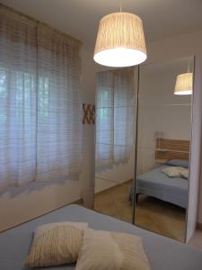 マリーナ・ディ・モーディカにあるMarina di Modica Suiteのベッドルーム1室(鏡、ベッド1台、ベッド1台付)
