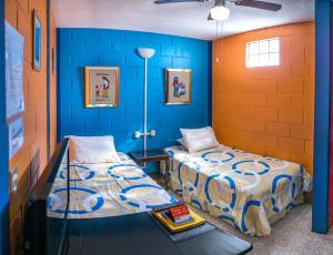 two beds in a room with blue walls at Hostal Guatefriends in Guatemala