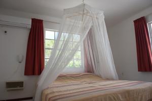 a bedroom with a bed with a mosquito net at Bantopa Apartments in Willemstad