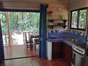 a kitchen with a blue counter top and a table at Ocean Melody 2 in Uvita