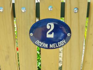 una señal azul en una valla de madera en Ocean Melody 2, en Uvita