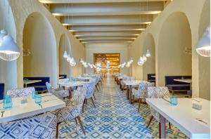 a dining room with white tables and chairs at Hideaway at Royalton Negril, An Autograph Collection All-Inclusive Resort - Adults Only in Negril