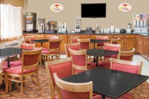 a restaurant with tables and chairs and a bar at Super 8 South by Wyndham in Bowling Green